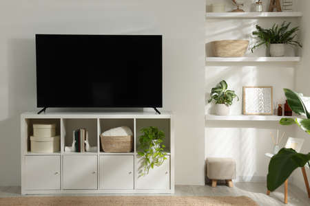 Stylish wide TV set on stand in roomの写真素材
