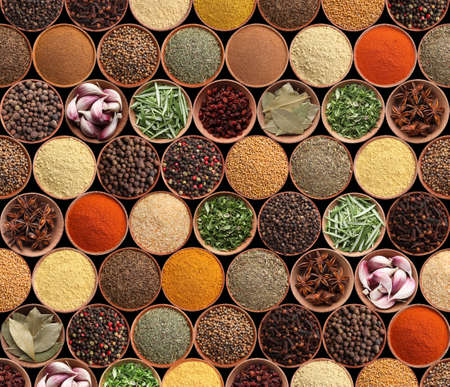 Collection of different aromatic spices and herbs on black background, flat layの写真素材