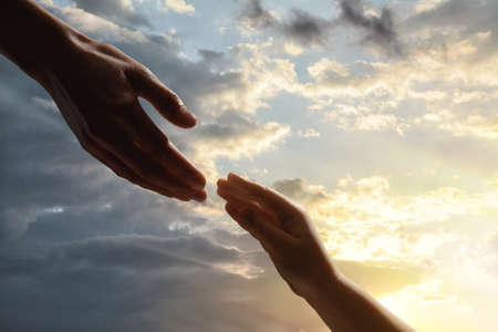 Godparent with child and beautiful sky with clouds at sunset on background, closeupの写真素材