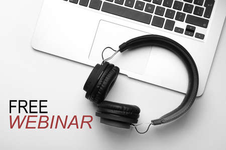 FREE WEBINAR. Modern headphones and laptop on white background, flat layの写真素材
