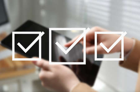 Illustration of check boxes with marks and woman using tablet indoors, closeupの写真素材