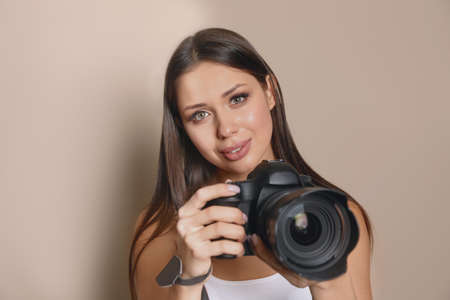 Professional photographer with camera on gray backgroundの写真素材