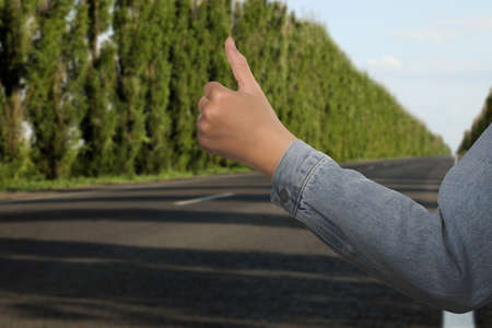 Woman catching car on road, closeup. Hitchhiking tripの写真素材