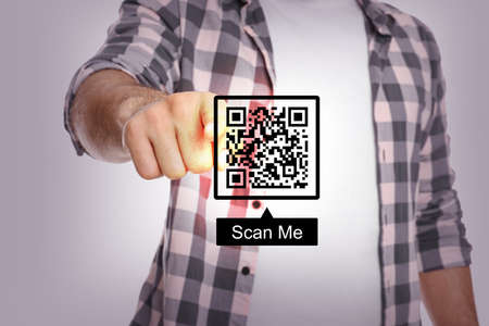 Man pointing at illustration of QR code on light gray background, closeupの写真素材