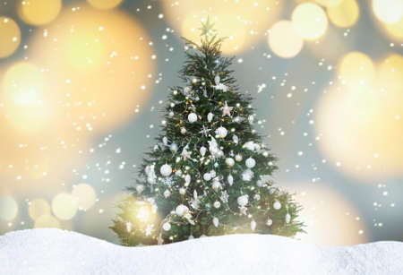 Beautifully decorated Christmas tree and snow on light background. bokeh effectの写真素材