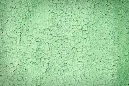 Texture of cracked light green wall as background, closeup