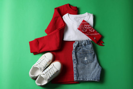 Stylish child clothes and shoes on green background, flat layの写真素材