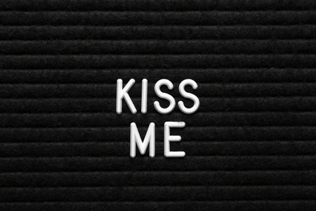 Phrase Kiss Me on black textured surfaceの写真素材