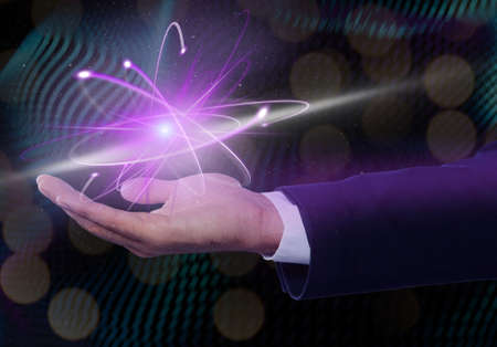 Man holding virtual model of atom on color background, closeup