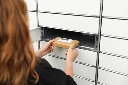 Woman taking package out of parcel locker, closeupの写真素材