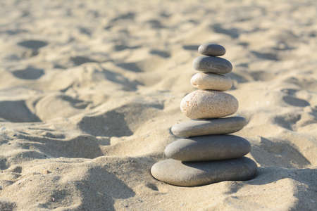 Stack of stones on sandy beach, space for textの写真素材