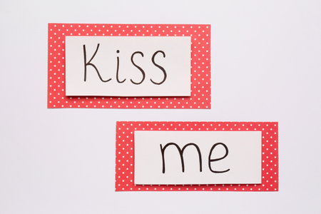 Cards with phrase Kiss me on white background, top viewの写真素材