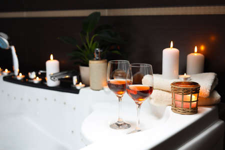 Bathtub with glasses of wine and candles indoors. romantic atmosphereの写真素材