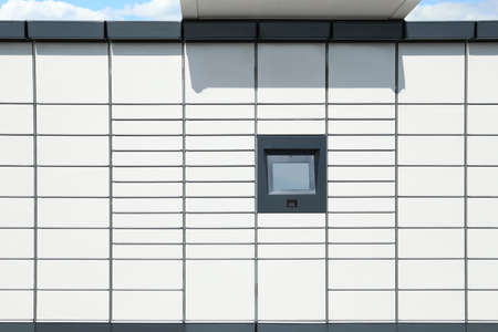Modern parcel locker with many postal boxes outdoors