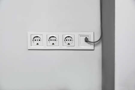 Power sockets with internet cable on white wall. electrical supplyの写真素材