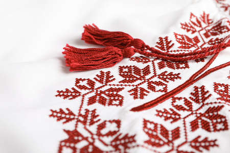 Beautiful red Ukrainian national embroidery on white fabric, closeupの写真素材