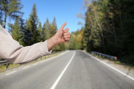 Woman catching car on road, closeup. Hitchhiking tripの写真素材