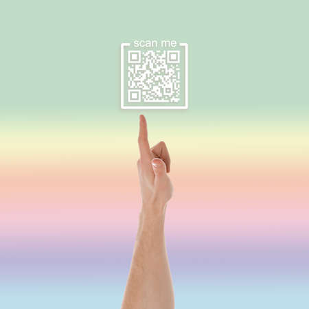 Man pointing at illustration of QR code on color background, closeup