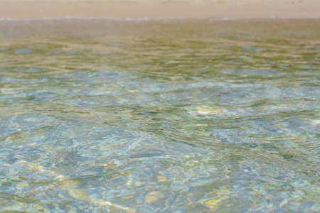 Beautiful sea water with ripples and sandy shoreの写真素材