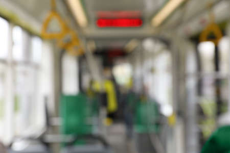 Blurred view of public transport interior with electronic display and handgrip handlesの写真素材