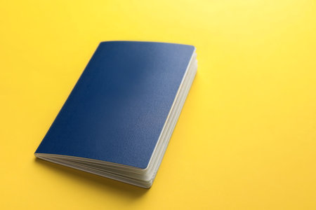 Blank blue passport on yellow background, space for textの写真素材