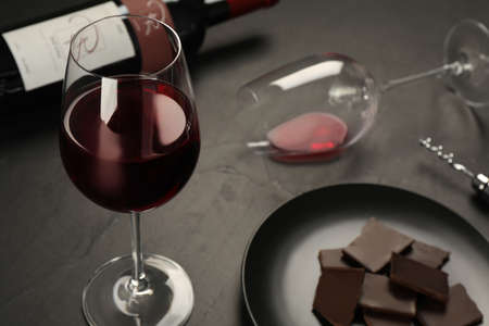 Tasty red wine and chocolate on black tableの写真素材