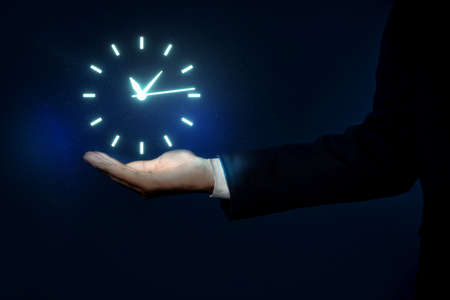 Man holding virtual icon of clock on dark background, closeup. time managementの写真素材
