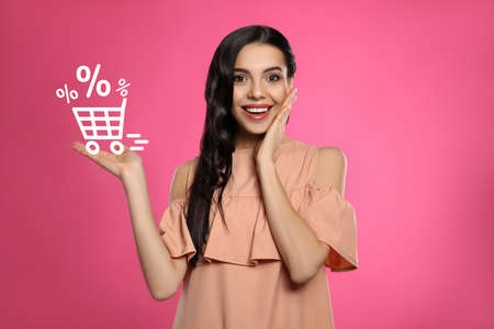 Surprised woman and illustration of shopping cart with percent signs on pink background. special promotionの写真素材