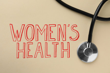 Words Women's Health and stethoscope on beige background, top viewの写真素材