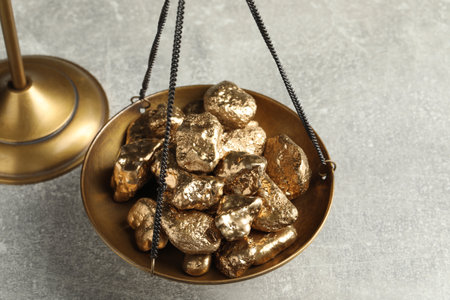 Vintage scales with gold nuggets on light gray table, closeupの写真素材