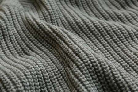 Beautiful gray knitted fabric as background, closeup