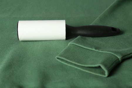 New lint roller with black handle on green sweatshirtの写真素材