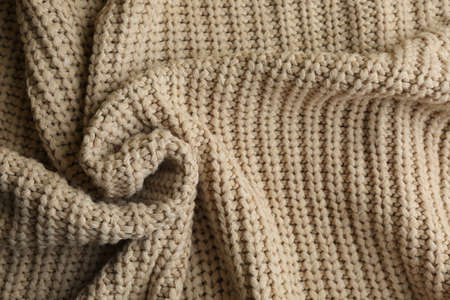 Beautiful beige knitted fabric as background, top viewの写真素材