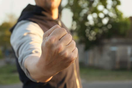 Angry man with clenched fist outdoors, closeupの写真素材