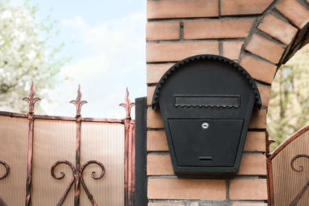 Vintage letter box on beige brick wall outdoors, space for text