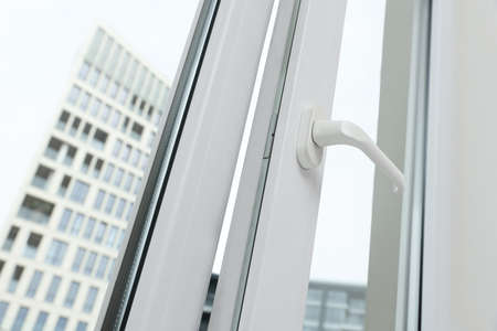 Open window with white plastic frame indoors, low angle view