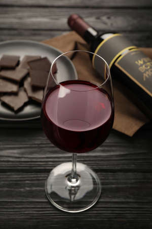 Tasty red wine and chocolate on black wooden tableの写真素材