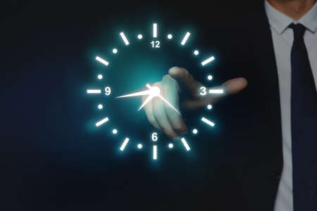 Man holding virtual icon of clock on dark background, closeup. time managementの写真素材