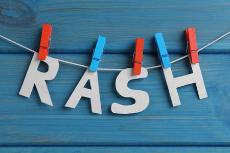 Word Rash hanging on turquoise wooden background