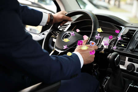 Man enjoying driving car feeling flower scented from ventilation, closeup. air freshener