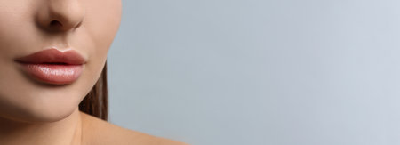 Woman with beautiful lips on light background, closeup view with space for text. banner designの写真素材