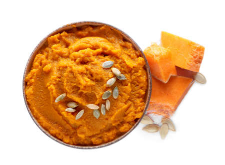 Delicious vegetable puree with pumpkin pieces and seeds on white background, top view. Health foodの写真素材