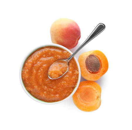 Apricot puree in bowl and fresh fruits on white background, top viewの写真素材