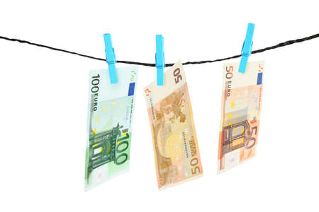 Money laundering. Euro banknotes hanging on clothesline against white backgroundの写真素材