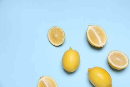 Many fresh ripe lemons on light blue background, flat lay. Space for textの写真素材