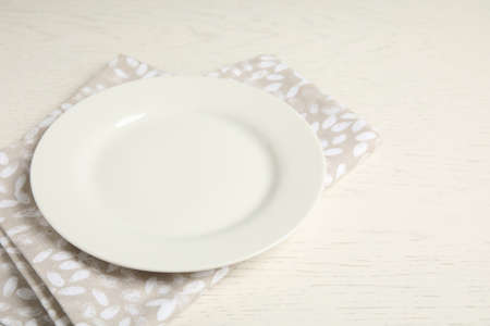 Empty plate and napkin on white wooden table, closeupの写真素材