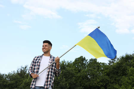Man with national flag of Ukraine outdoorsの写真素材