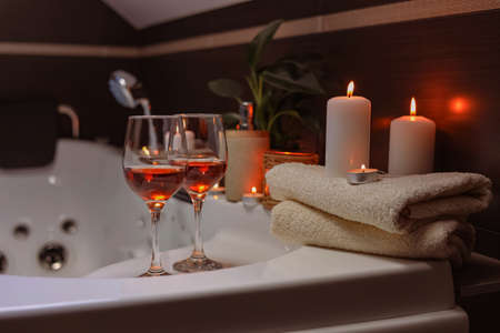 Bathtub with glasses of wine and candles indoors. romantic atmosphereの写真素材