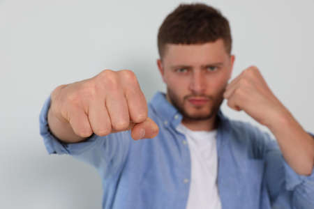Young man ready to fight against white background, focus on hand. Space for textの写真素材