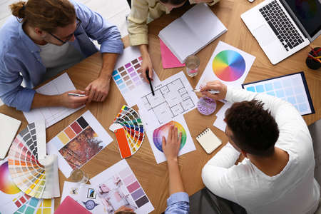 Professional team of interior designers working at table, top view